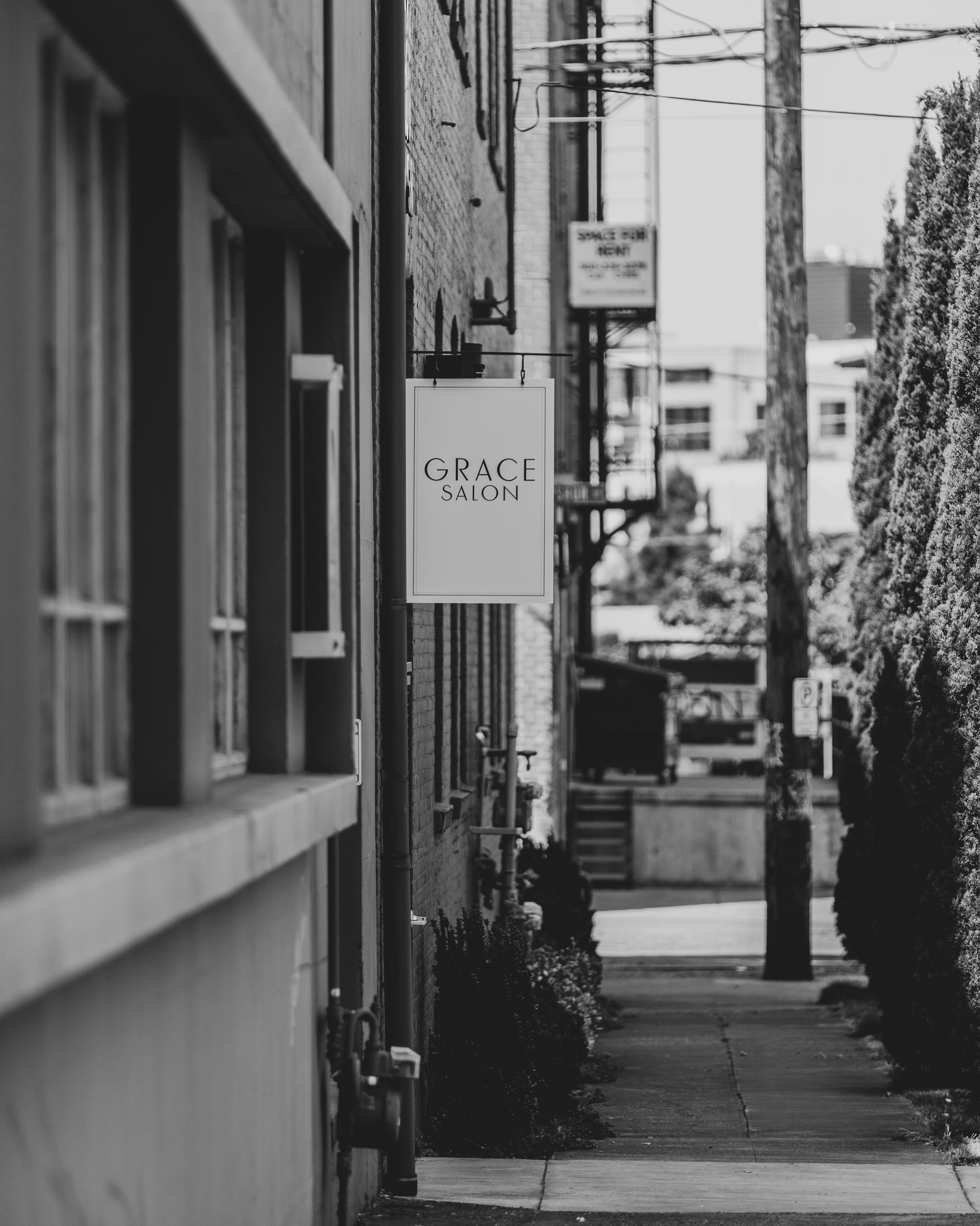 grayscale photo of a man walking on a sidewalk